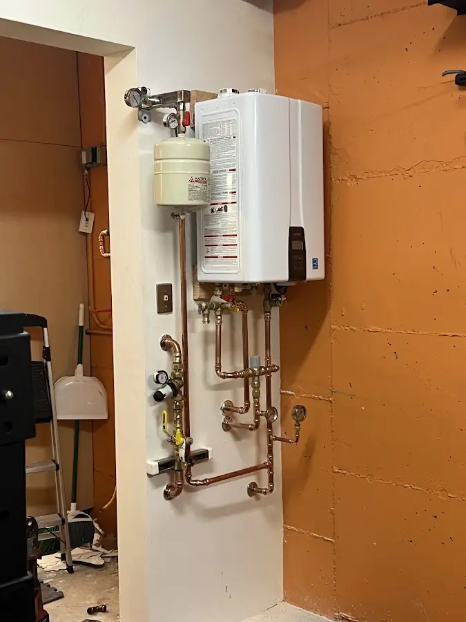 Plumbing technician inspecting water heater connections in Grove City